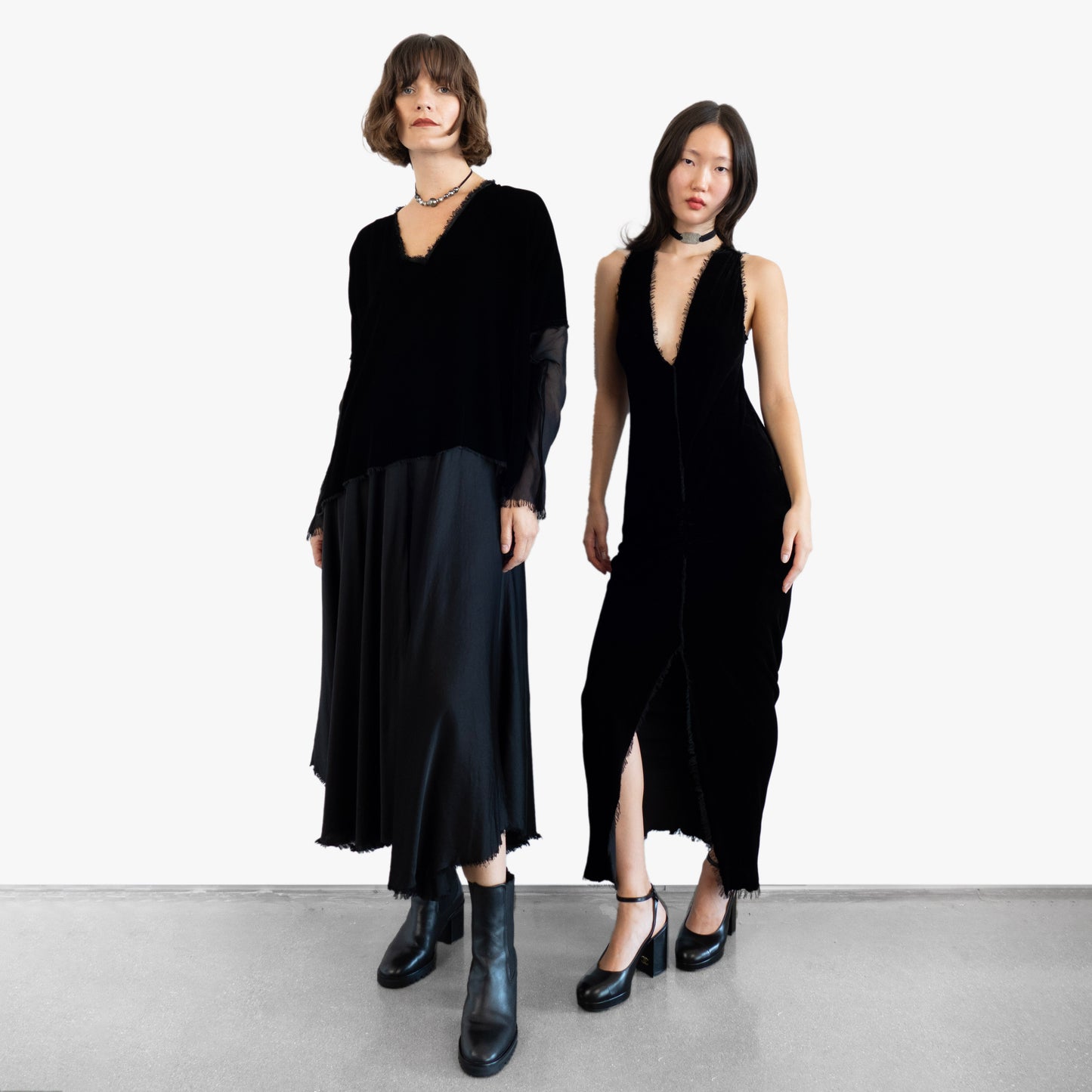 Model wearing a black velvet dress and another model wearing a black velvet blouse and black silk skirt