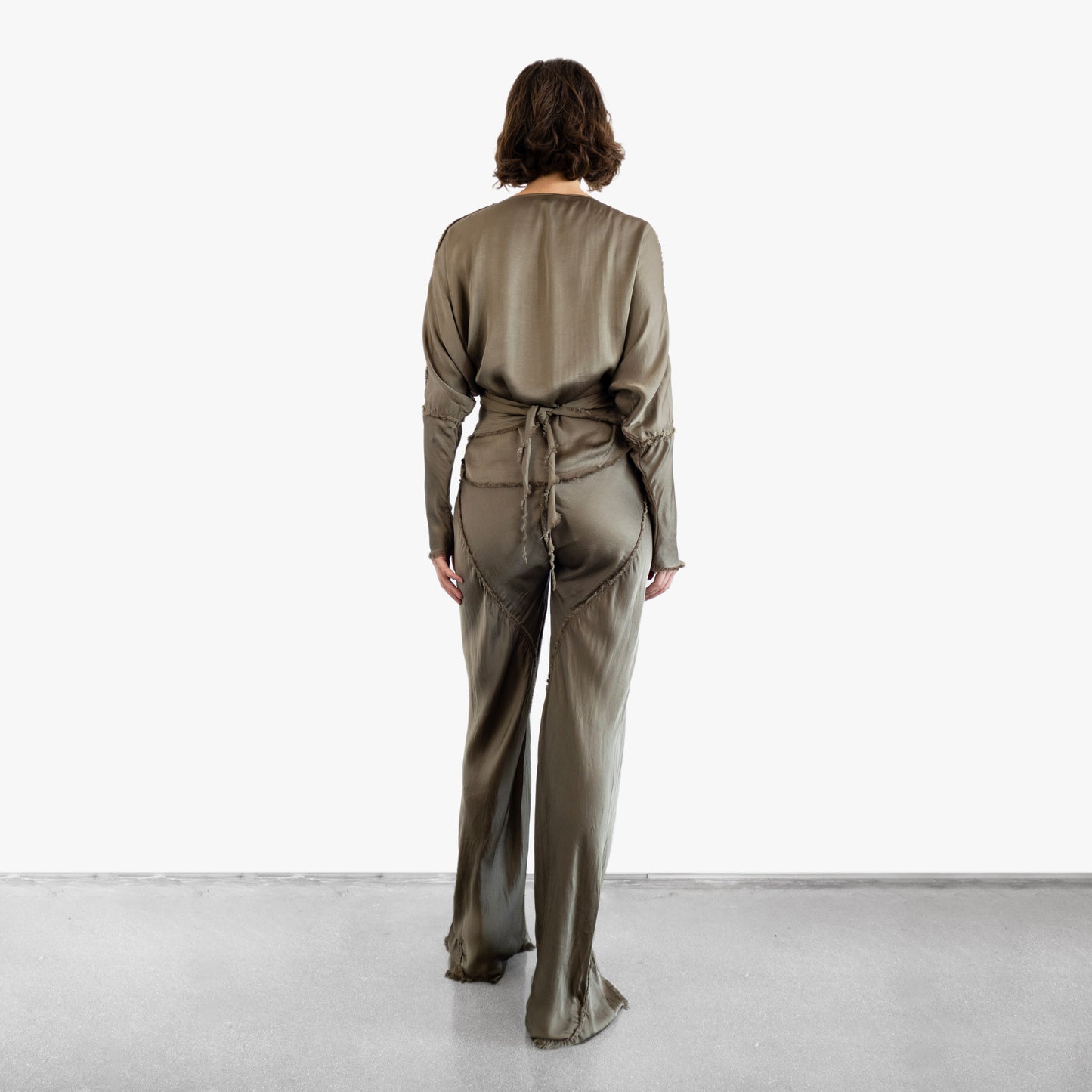 Model wearing a green silk wrap top and silk pants