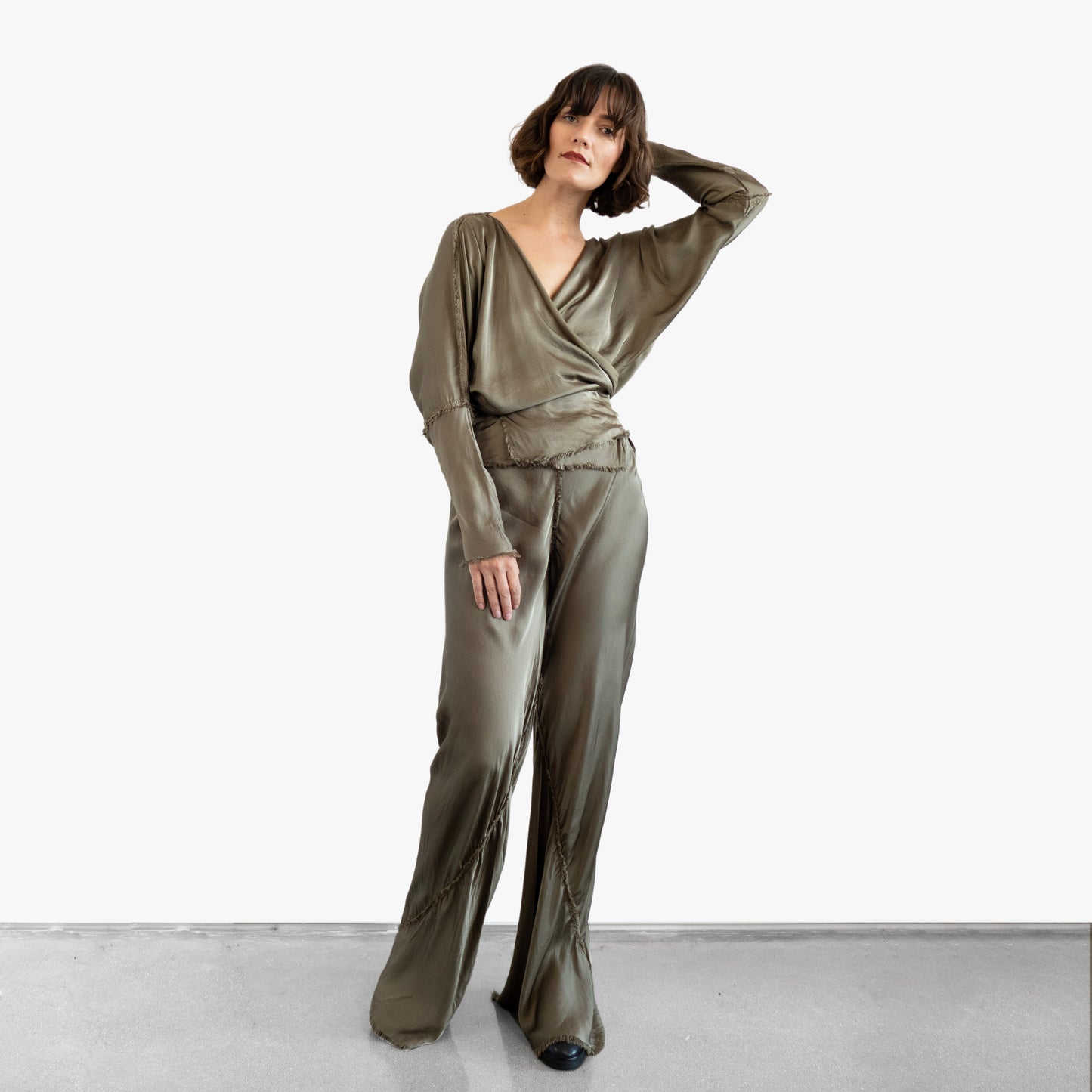 Model wearing a green silk wrap top and pants