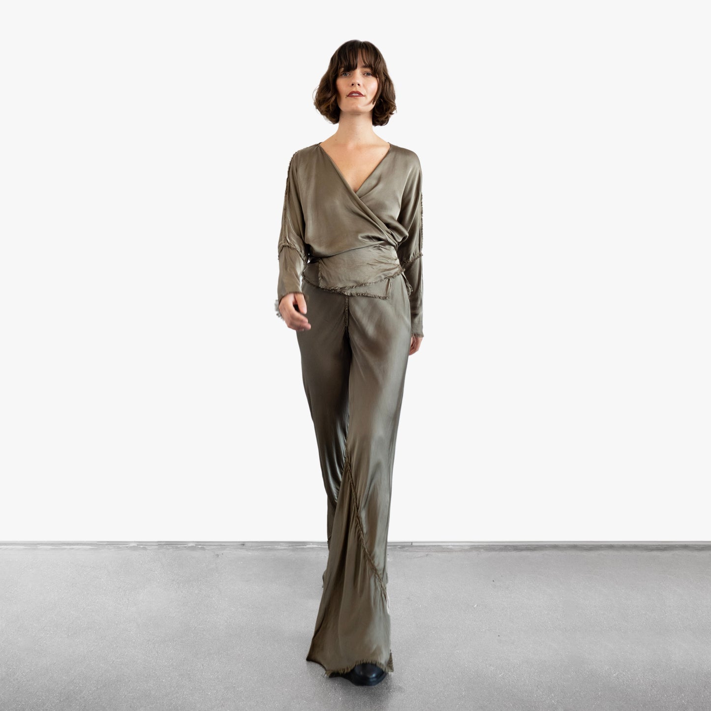 Model wearing a green silk wrap top and pants