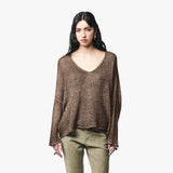 A woman modeling a brown v-neck ribbed knit long-sleeve sweater, paired with olive green pants, against a plain light gray background.
