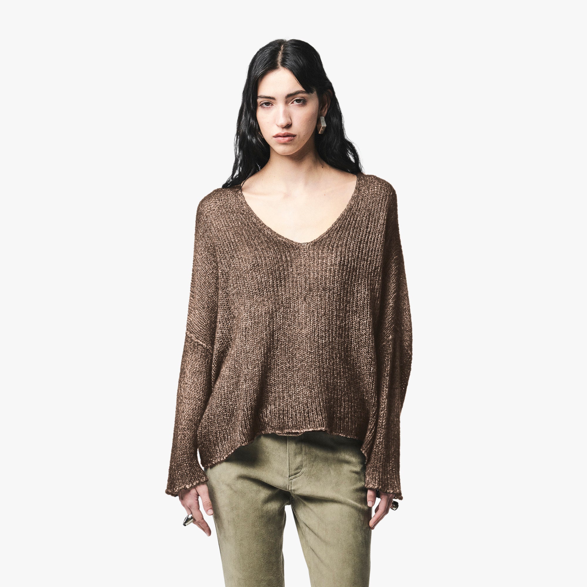 A woman modeling a brown v-neck ribbed knit long-sleeve sweater, paired with olive green pants, against a plain light gray background.