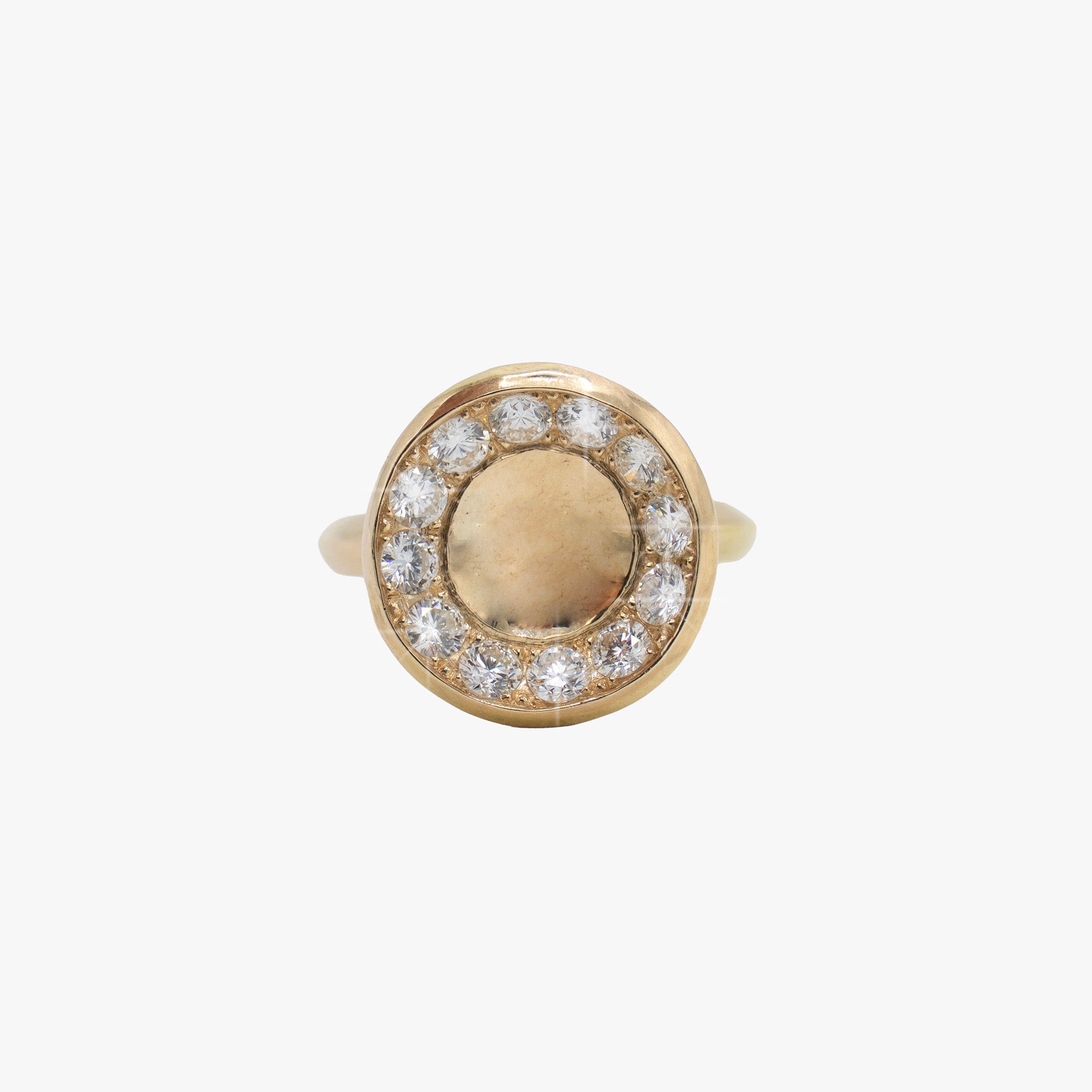 A 14K gold circular cocktail ring set with diamonds around it.