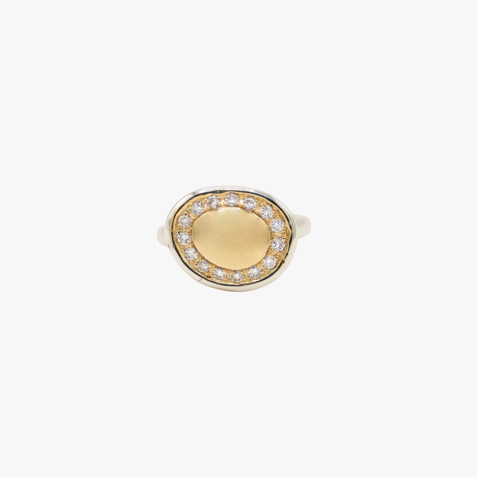 A two-tone oval ring featuring a smooth gold center surrounded by a halo of small clear stones, set in a silver-toned band.