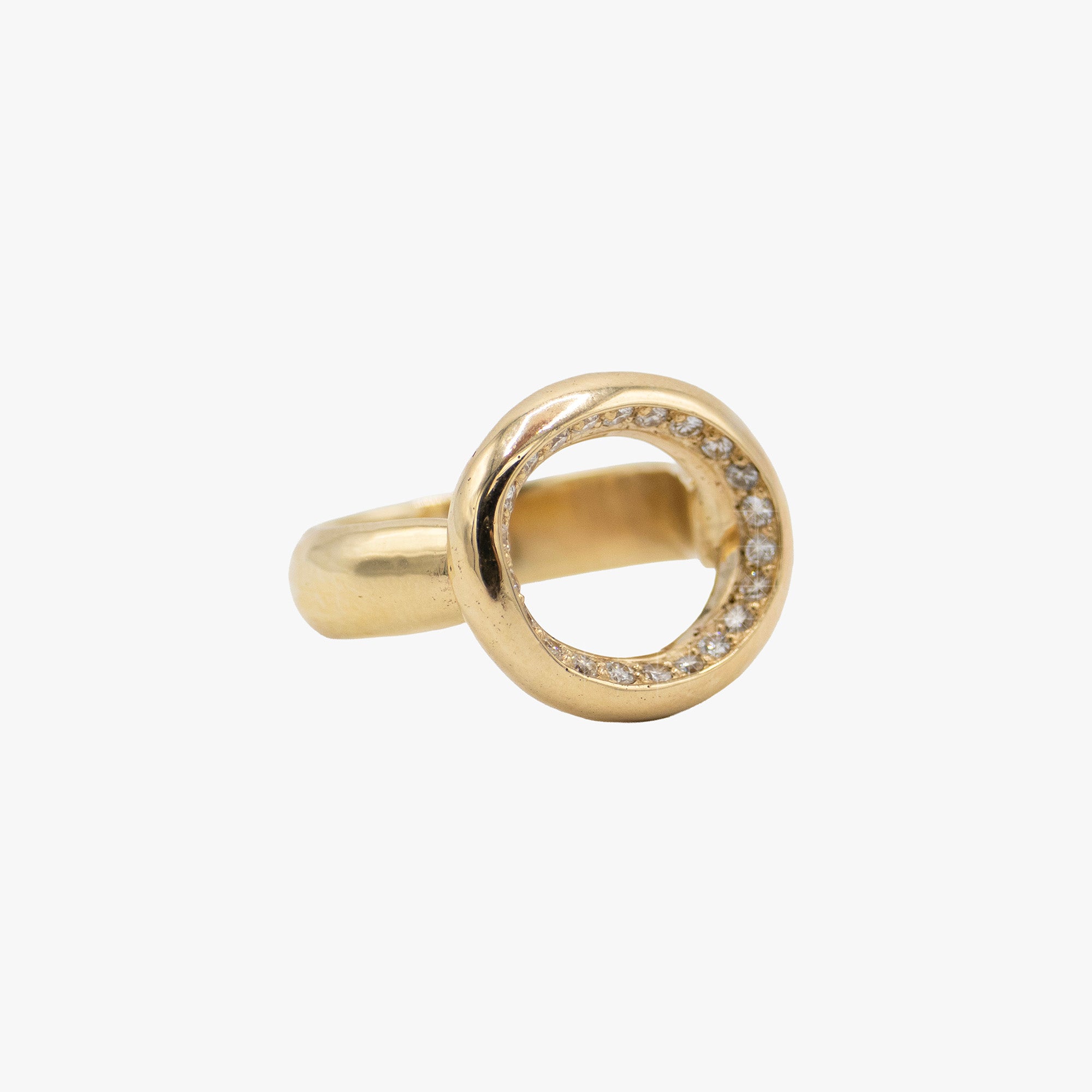 A gold ring featuring a circular openwork top set with small clear stones along the inner edge.