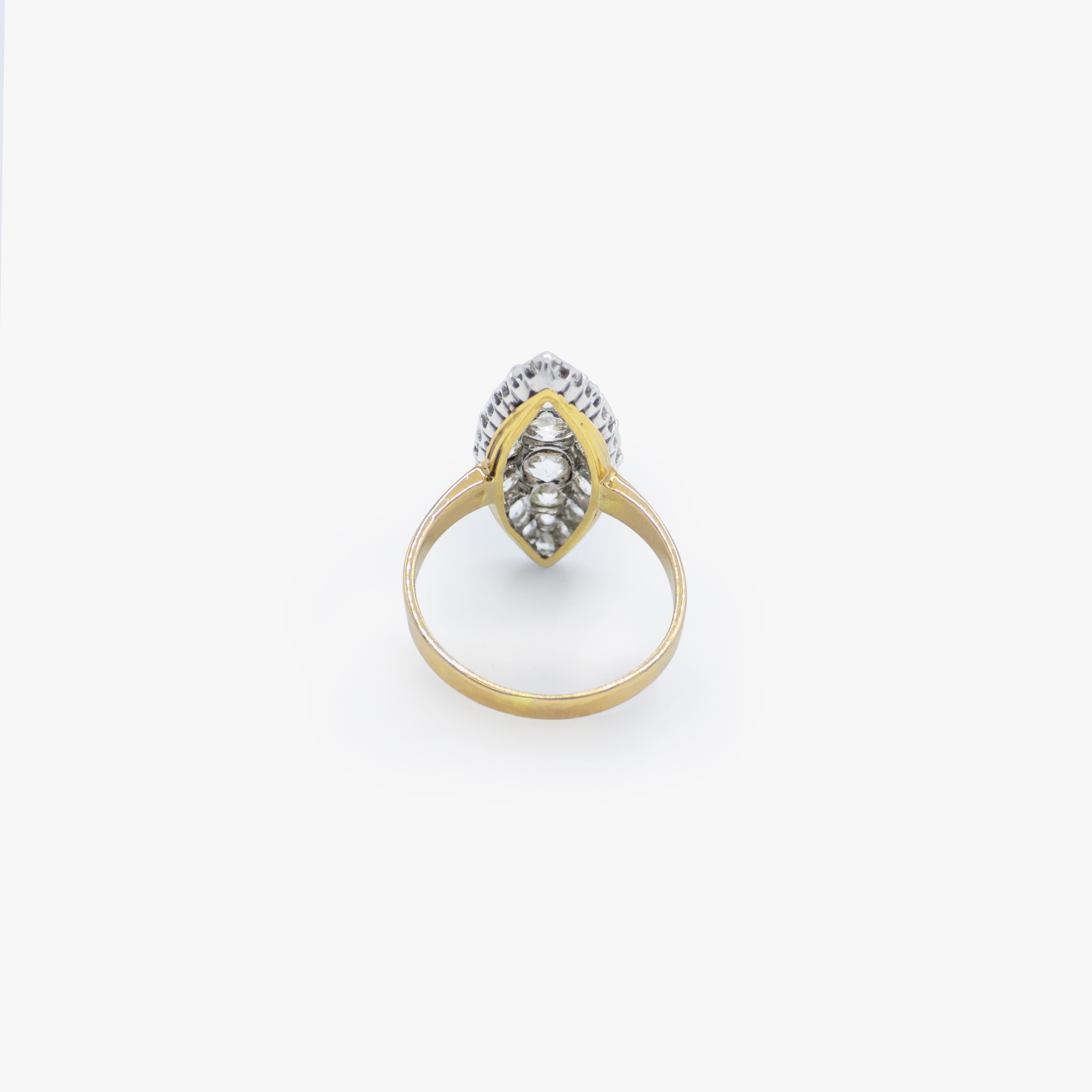 A vintage-style two-tone ring featuring a marquise-cut diamond center stone surrounded by smaller diamonds, set in a yellow gold and silver-tone band, shown on a plain white background.