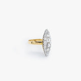 A yellow gold ring with an oval pavé diamond setting, photographed on a clean, light gray background.