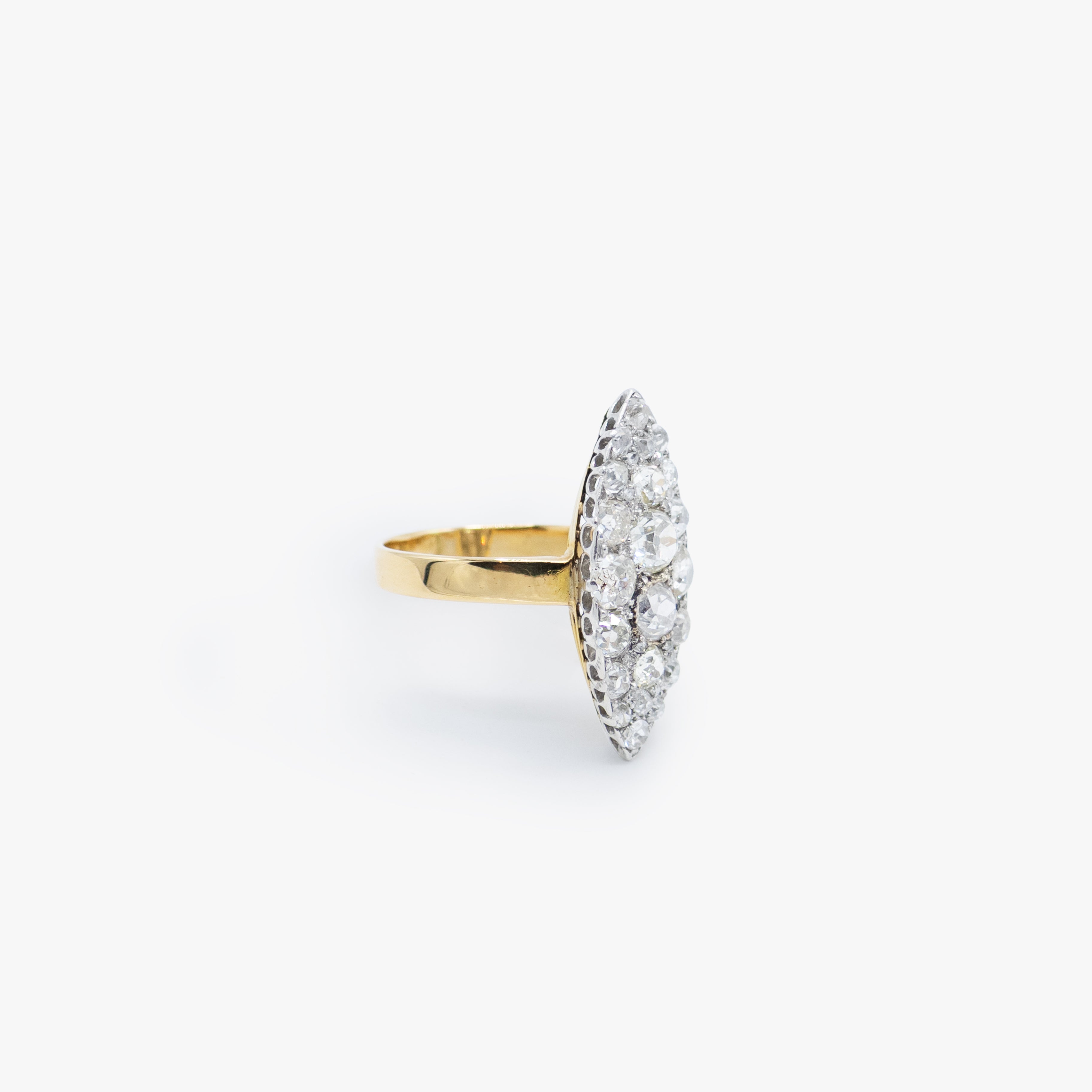 A yellow gold ring with an oval pavé diamond setting, photographed on a clean, light gray background.