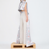 Barbara Bologna Floral Print Stolla Vest — back view showing the vest's completely open back, silver-grey floral print satin, styled with simple cream trousers made in Italy