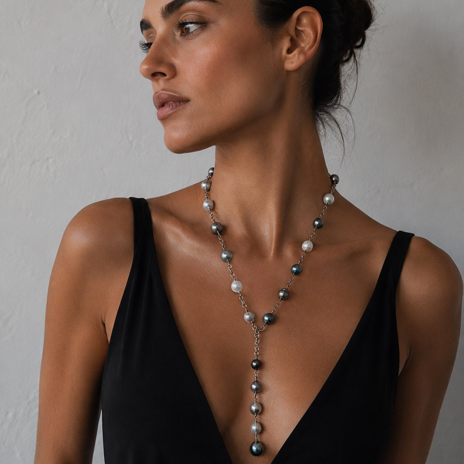 A woman wearing a pearl lariat necklace on sterling silver chain