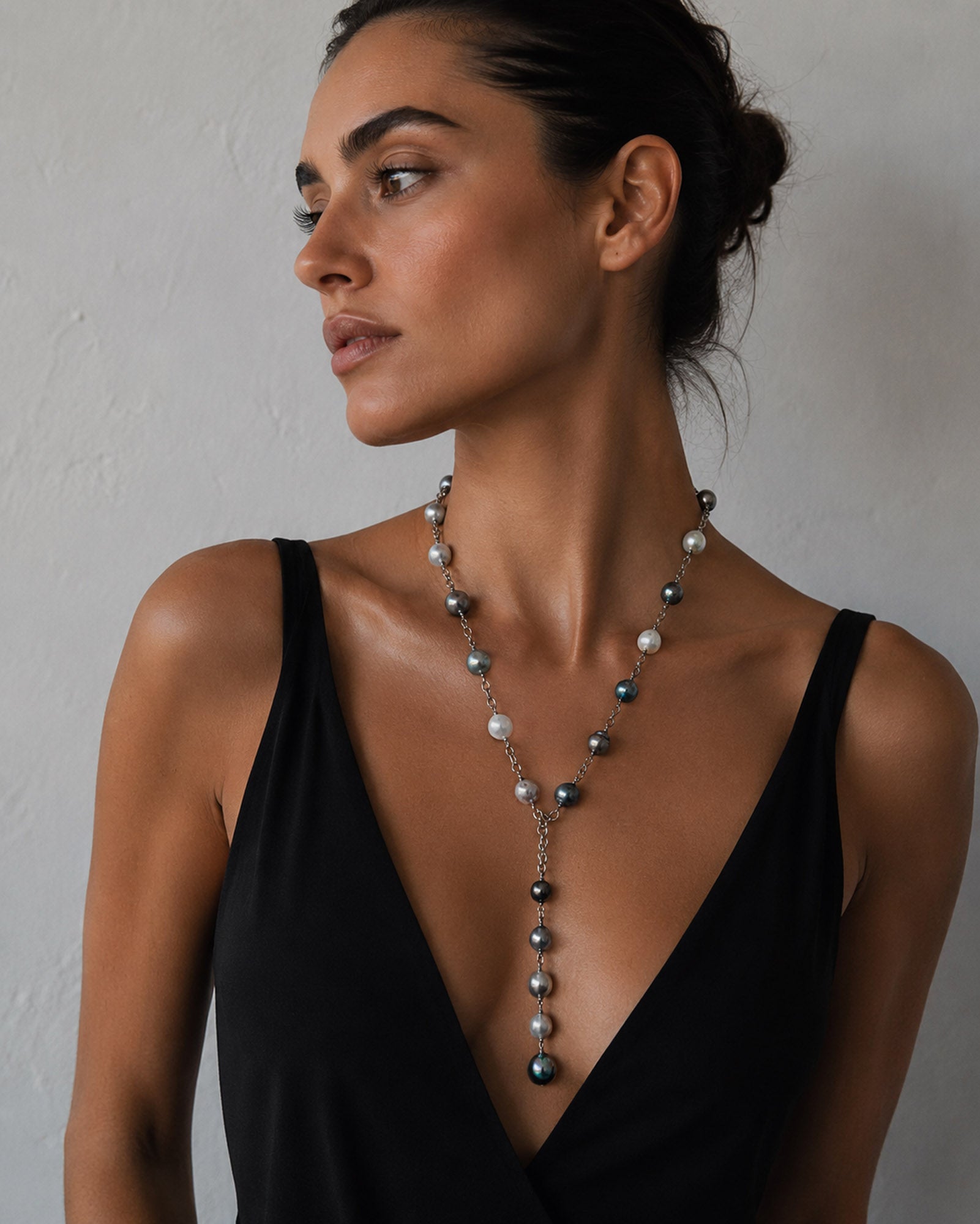A woman wearing a pearl lariat necklace on sterling silver chain