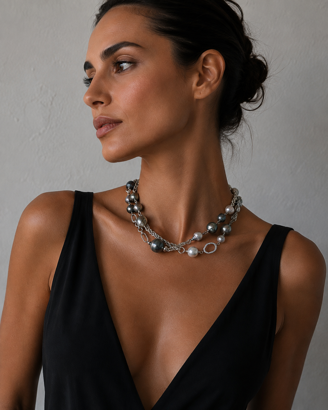 A woman wearing a pearl and diamond necklace on a sterling silver chain