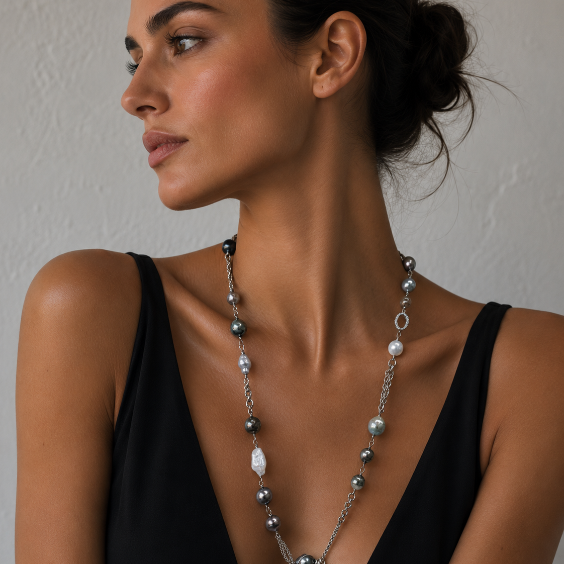 A woman wearing a Tahitian pearl and Baroque pearl necklace