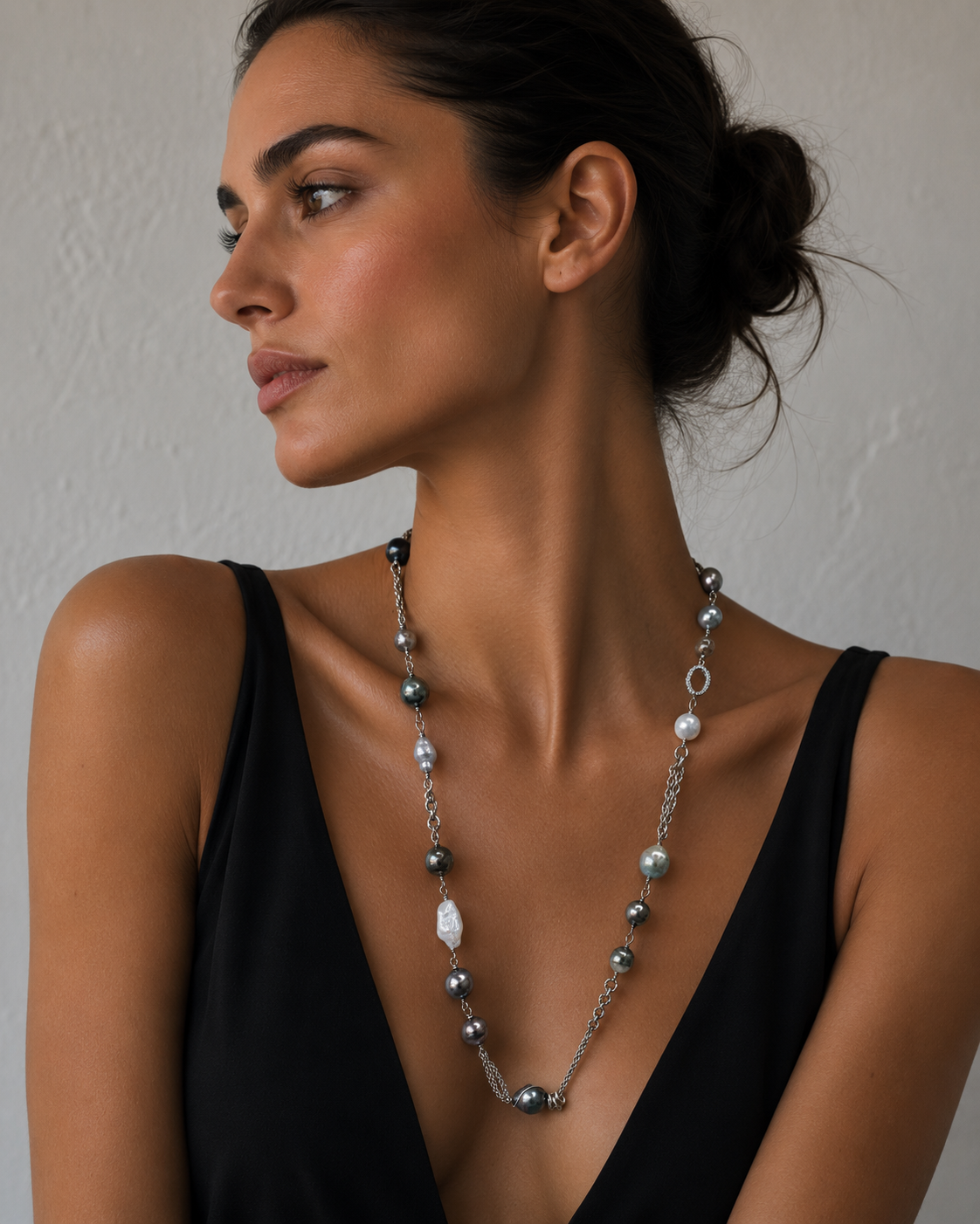 A woman wearing a Tahitian pearl and Baroque pearl necklace