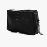 A black pebbled leather bag with a top zipper, decorative vertical stitching, and a silver-tone chain accent, shown on a light gray background.