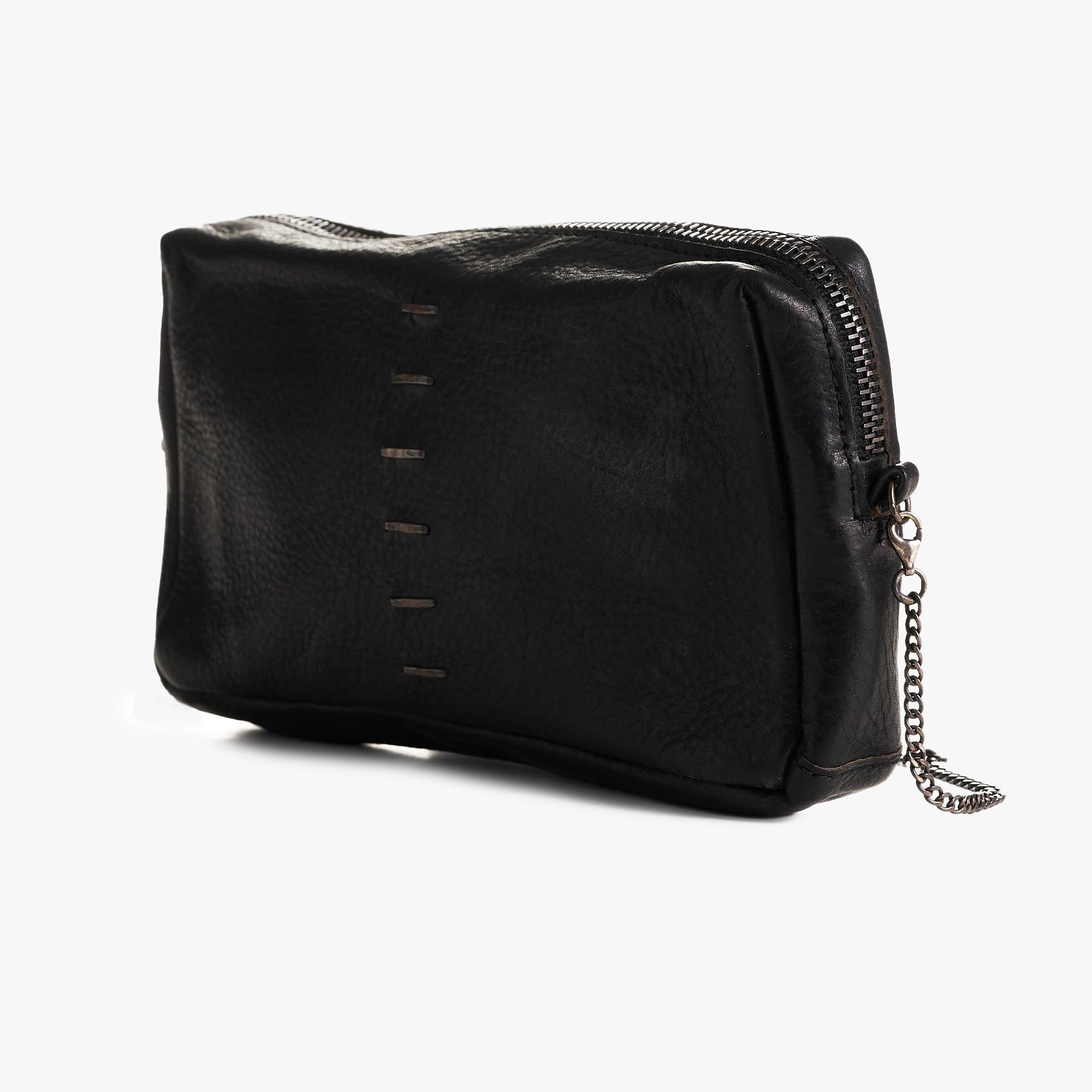 A black pebbled leather bag with a top zipper, decorative vertical stitching, and a silver-tone chain accent, shown on a light gray background.