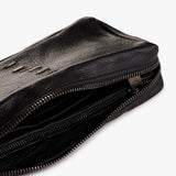 Close-up of a black textured leather zippered bag with a partially unzipped silver metal zipper, shown on a clean white background.