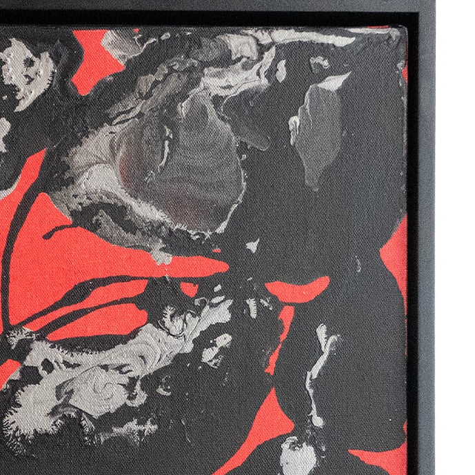 Abstract framed artwork featuring expressive black and gray brushstrokes with vivid red gaps, presented in a black frame against a white background.