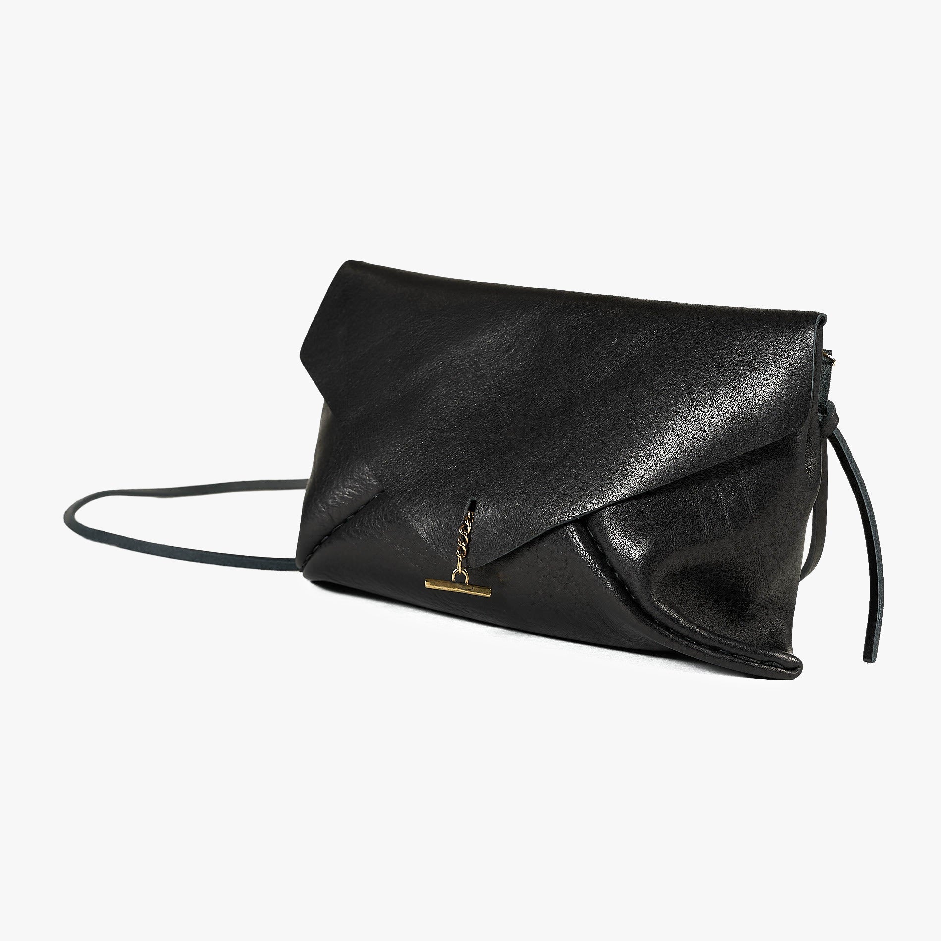 A black leather envelope clutch bag with a small gold-tone logo clasp and a thin black shoulder strap, photographed on a clean white background.