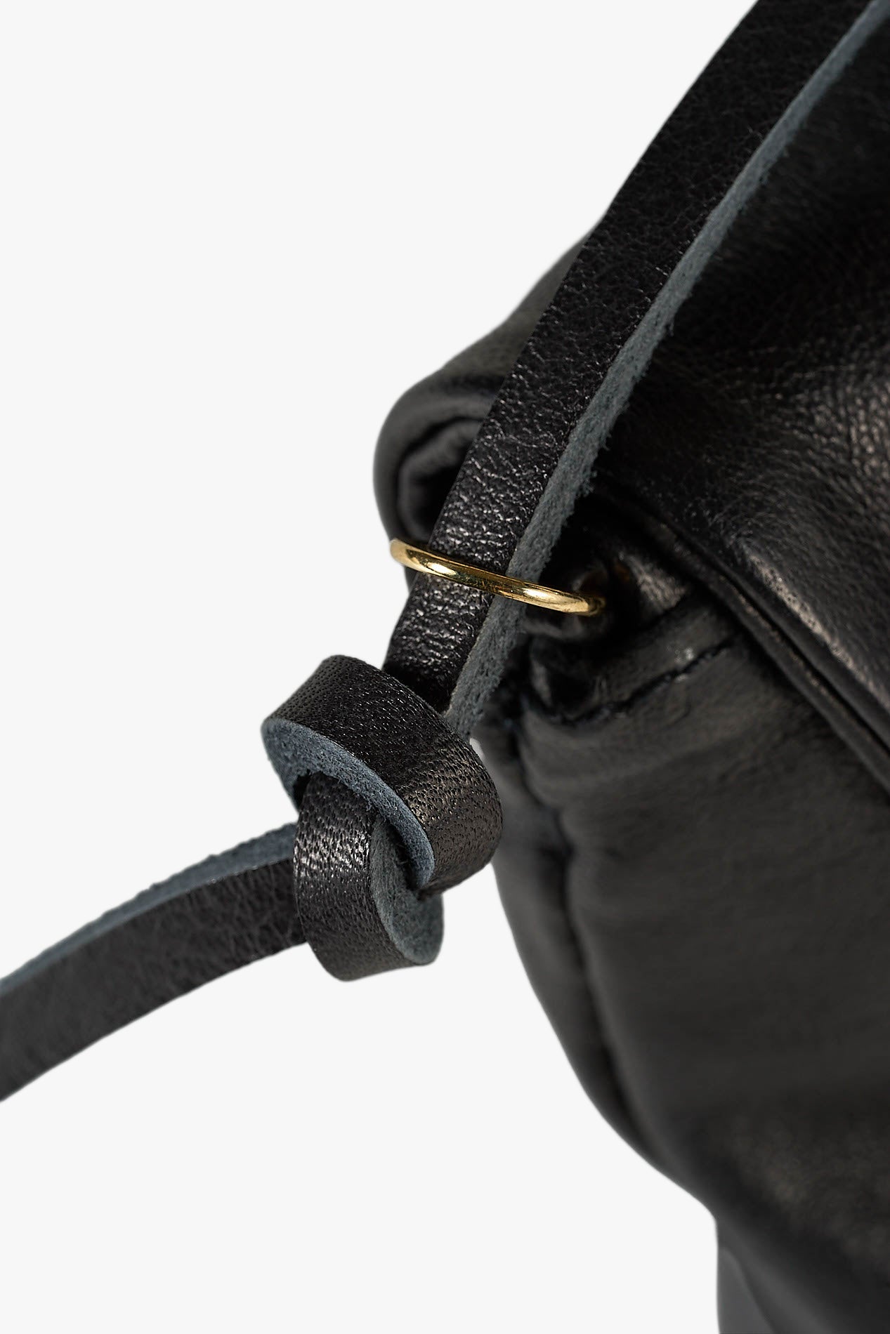 Close-up detail of a black leather bag strap knotted through a gold-tone ring on a white background.