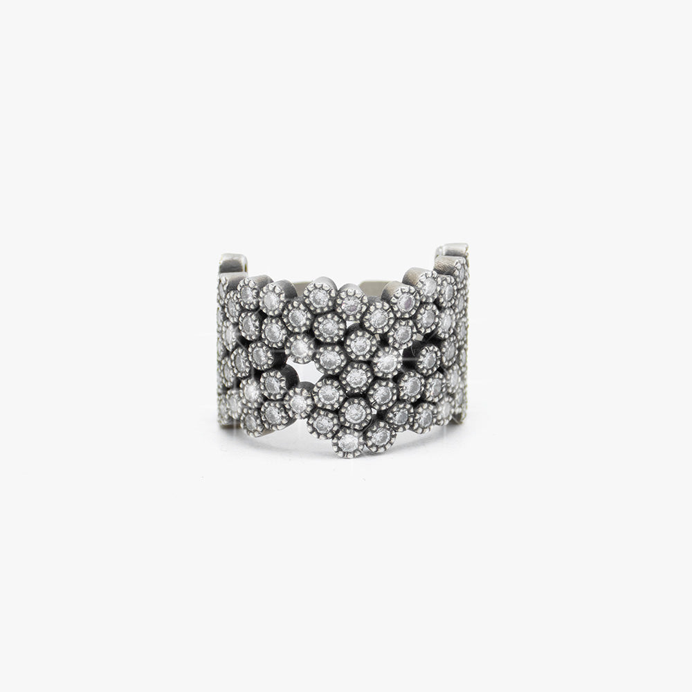 A wide silver cuff ring embellished with multiple rows of diamonds, photographed on a clean white background.
