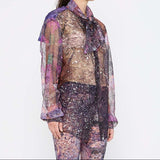 Barbara Bologna Sheer Print Open-Back Blouse — close-up side view, sheer abstract print blouse with neck tie and voluminous sleeves in purple and mauve tones, made in Italy