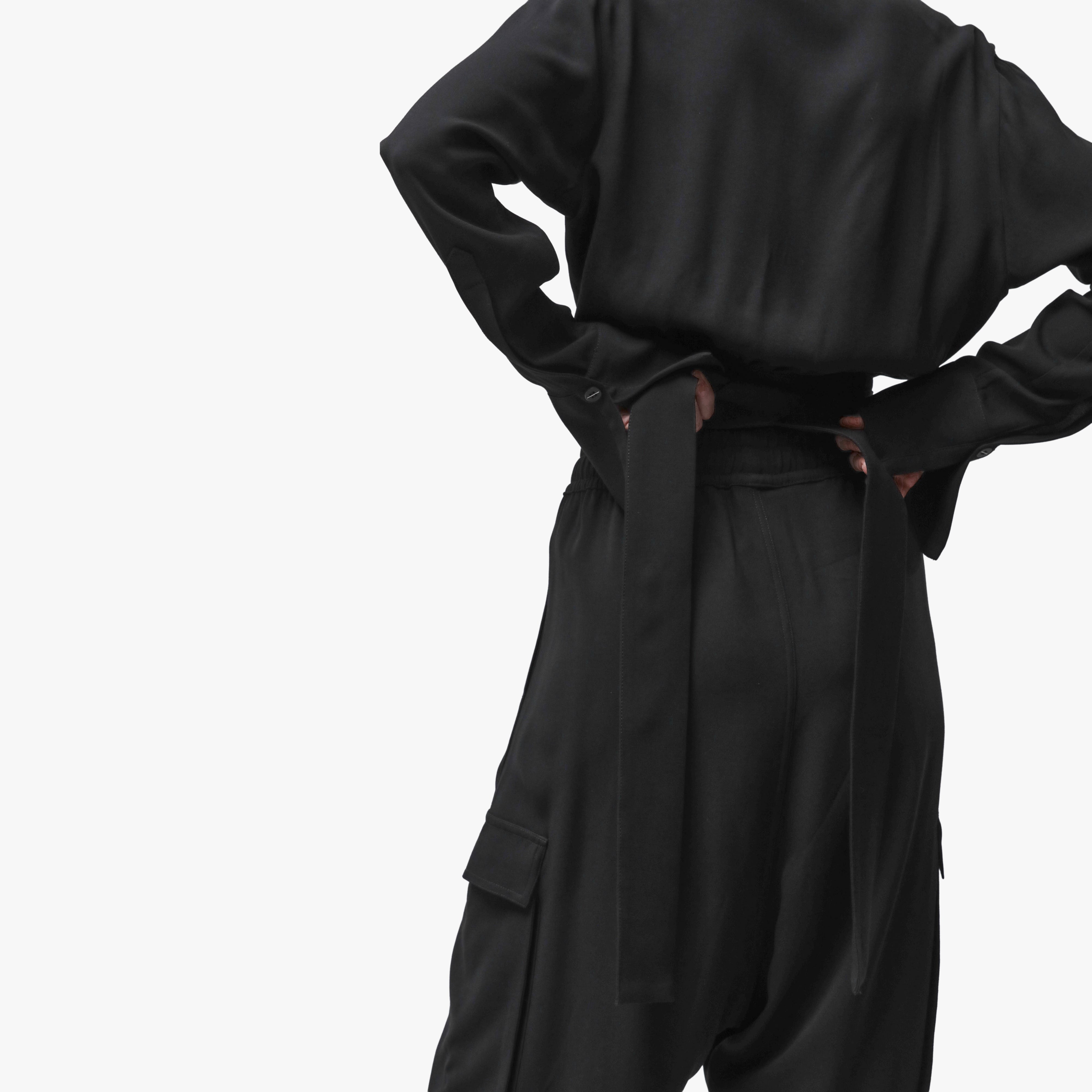 Woman wrapping a black top behind her