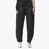 A woman wearing black barrel leg jeans
