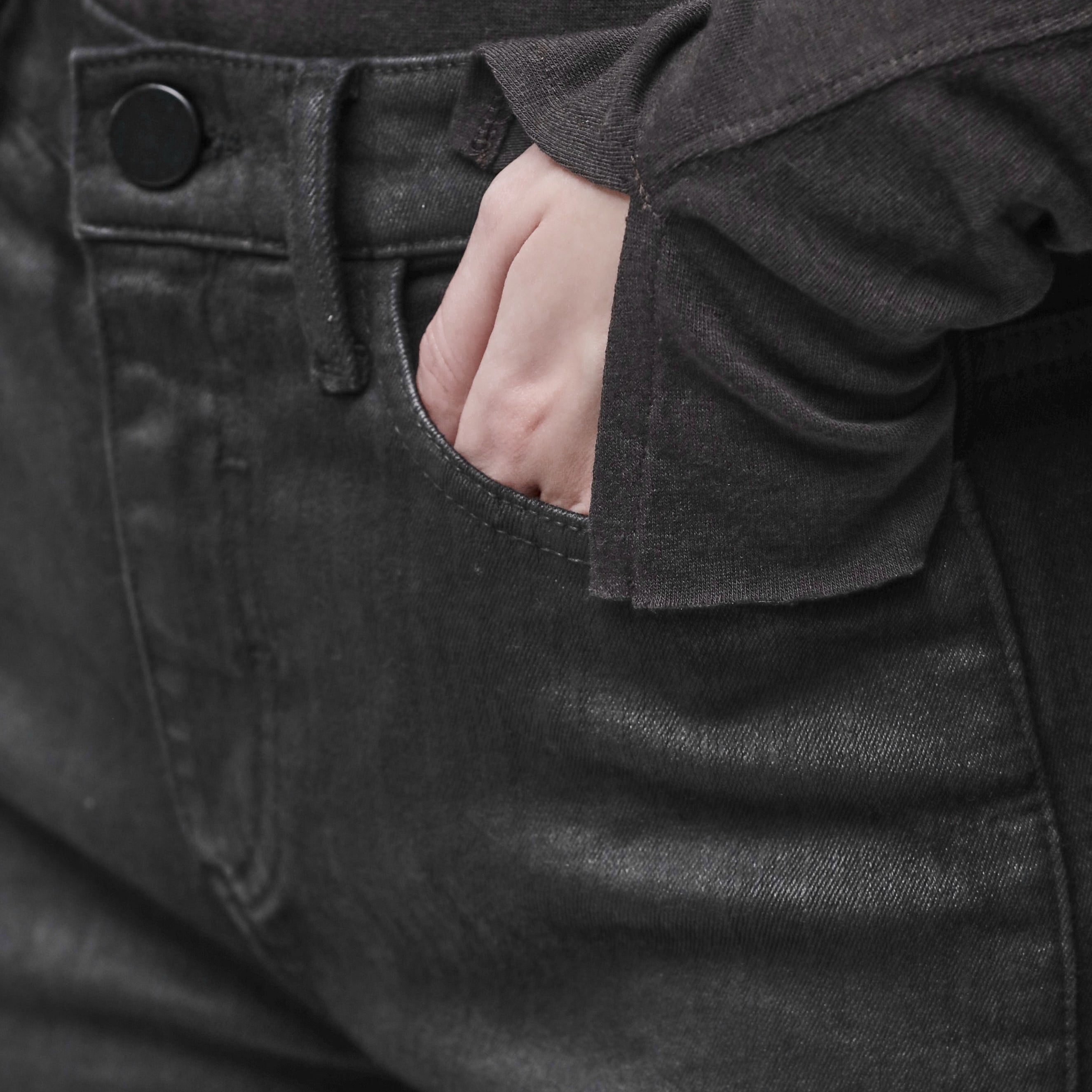 A woman's hand in the pocket of black jeans
