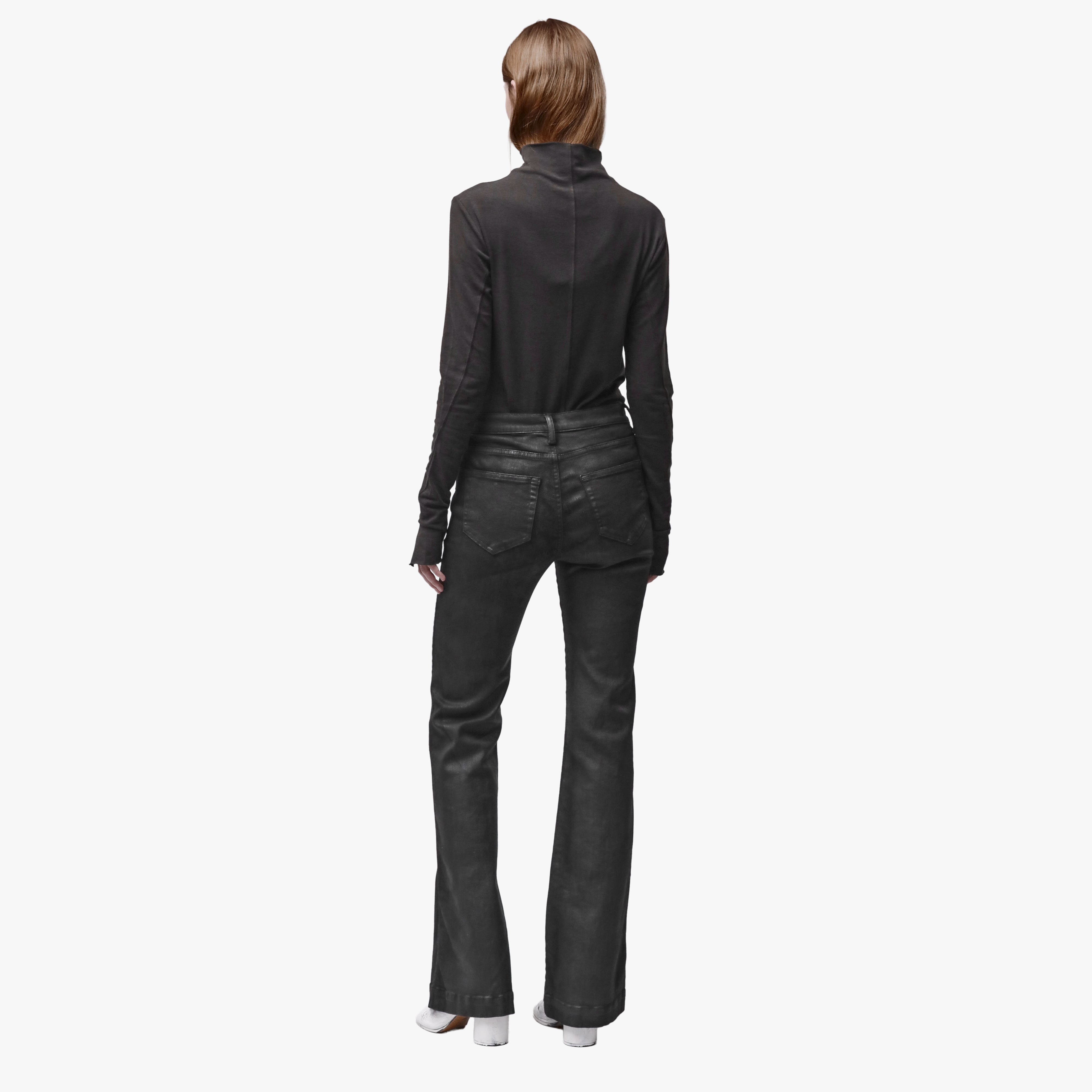 Back view of a woman wearing black flared jeans and a brown mock turtleneck shirt