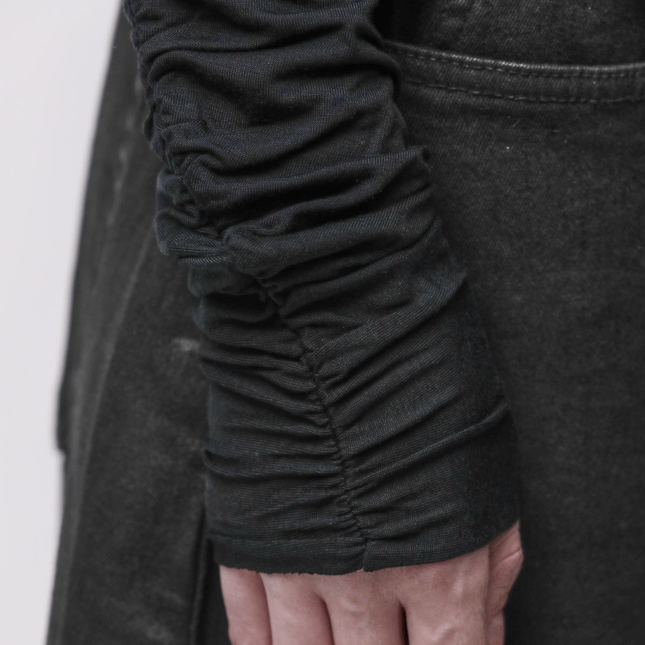 Sleeve detail of a woman wearing a black top