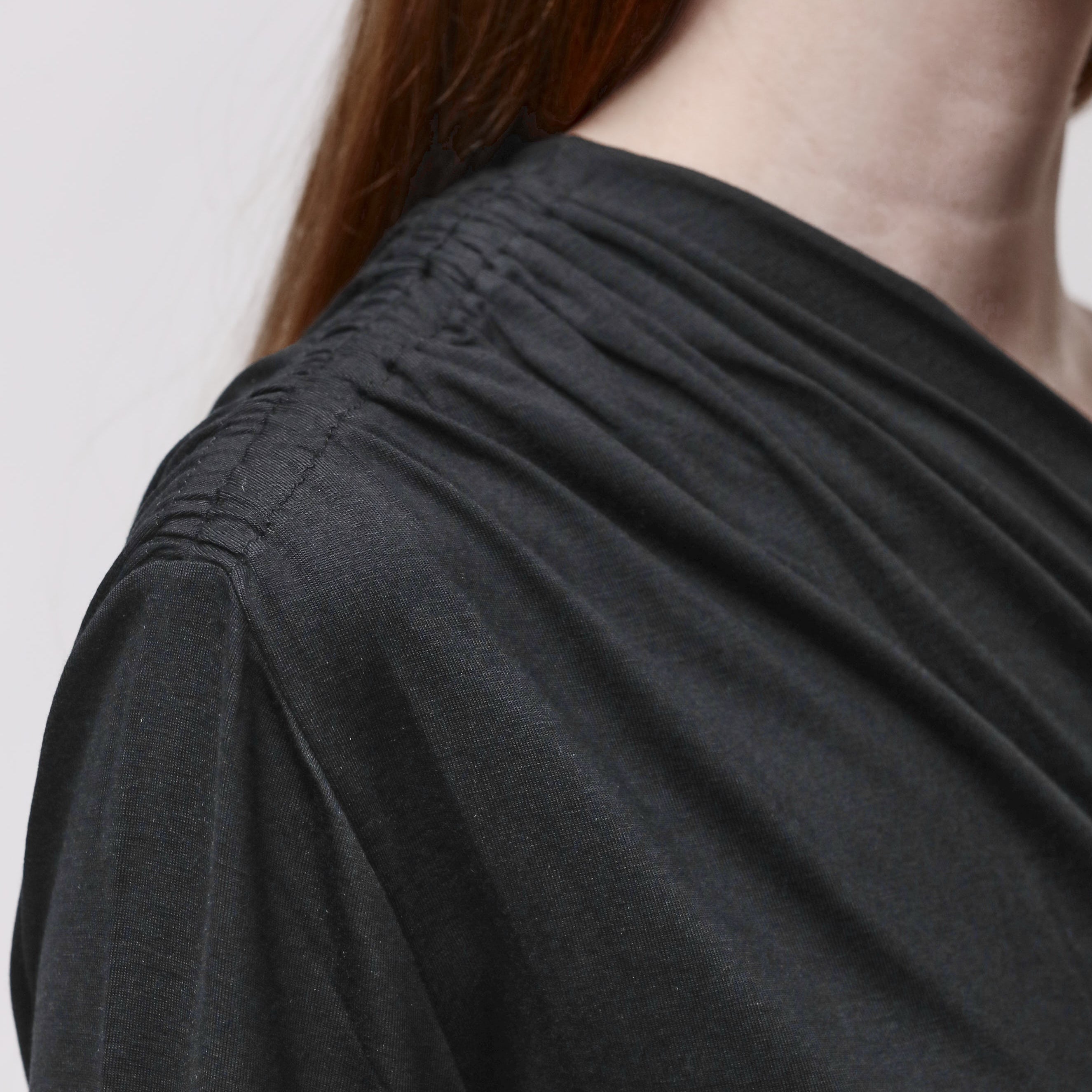 Shoulder detail of a woman wearing a black top