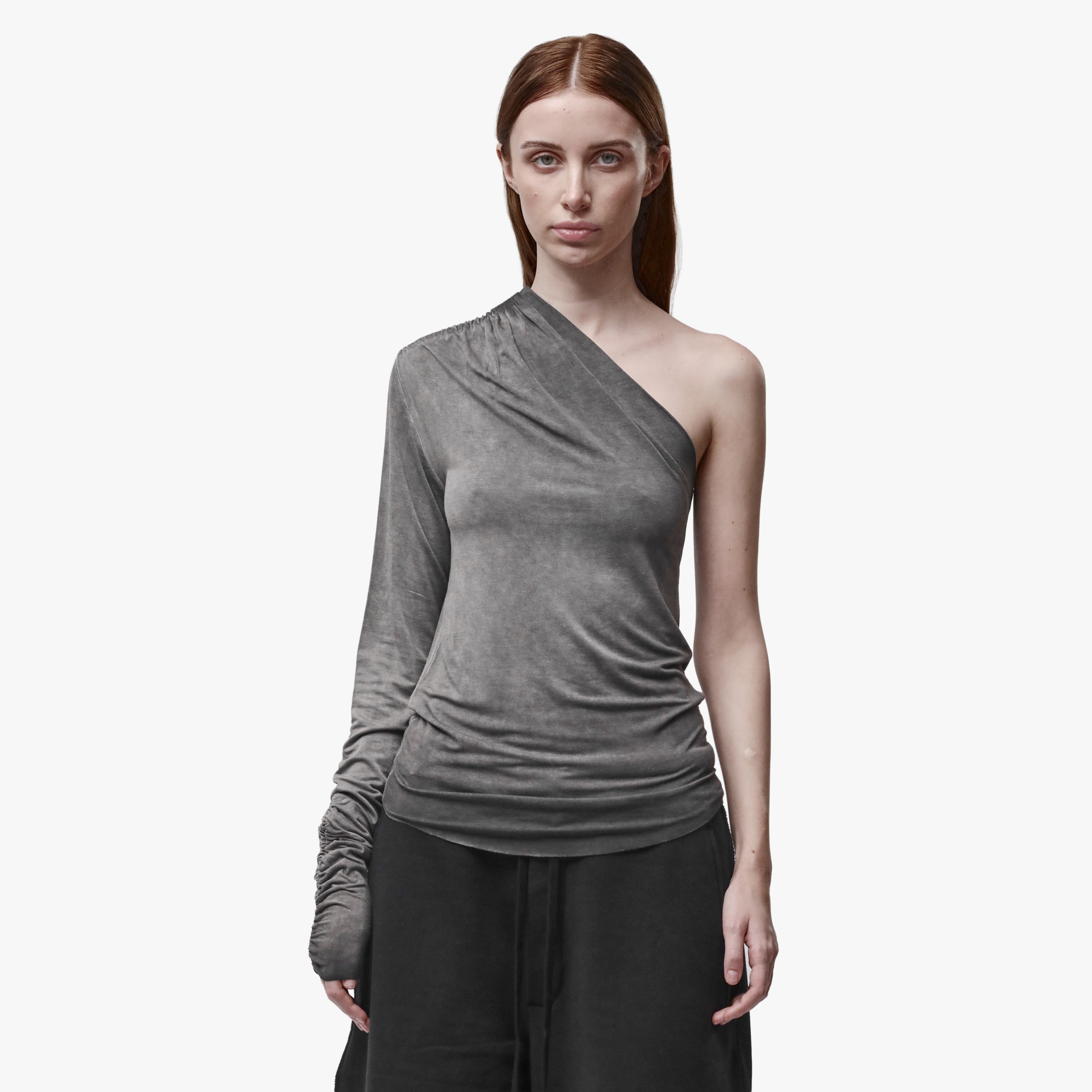 A woman wearing an asymmetrical grey top and black barrel pants