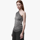 A woman wearing an asymmetrical grey top and black barrel pants