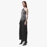 3/4 angle of a woman wearing an asymmetrical grey top and black barrel pants