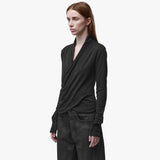 A woman wearing a long sleeve black wrap top 