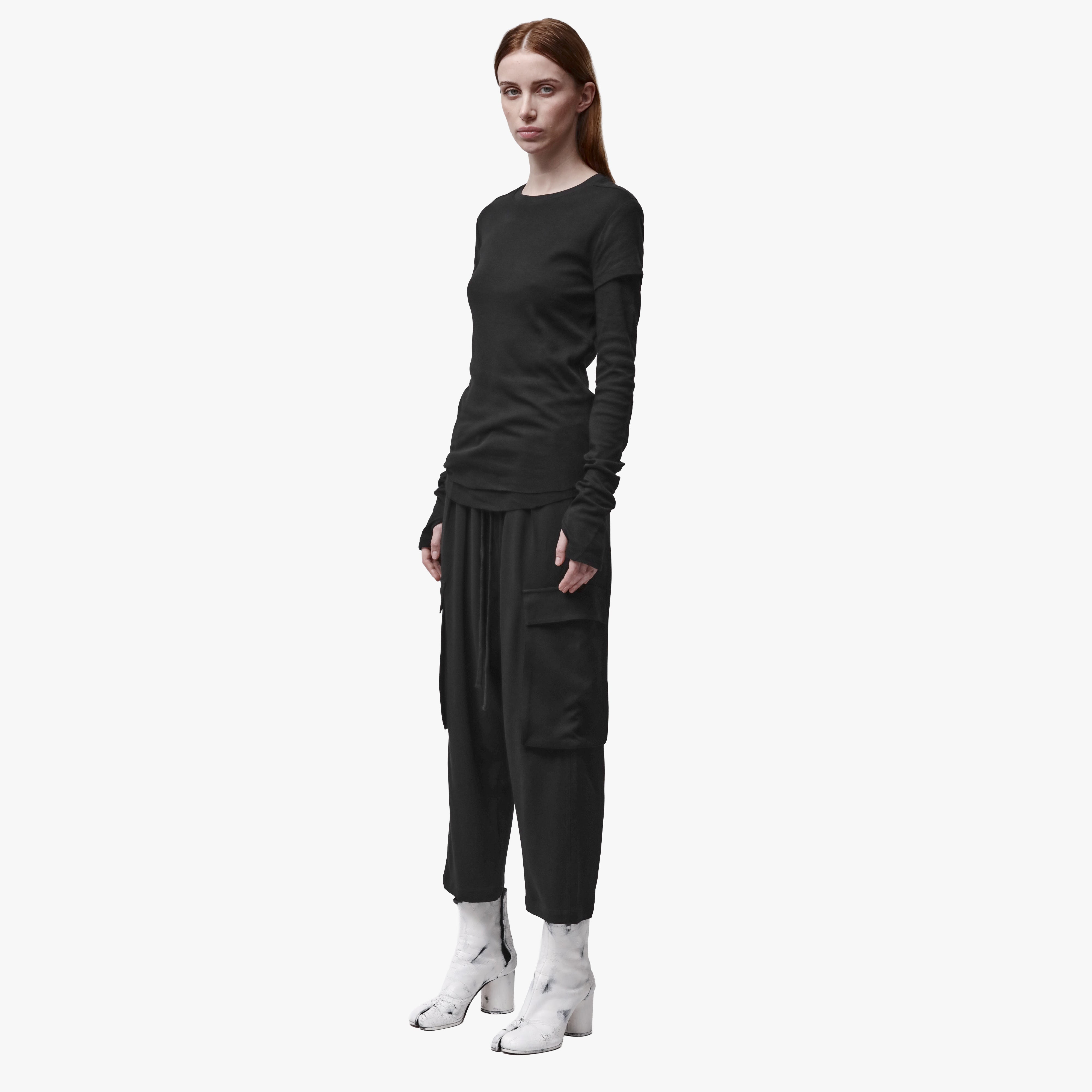 A woman wearing a crew neck t-shirt and black pants