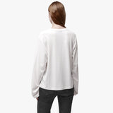 Back view of a woman wearing a relaxed white long sleeve crew neck t-shirt