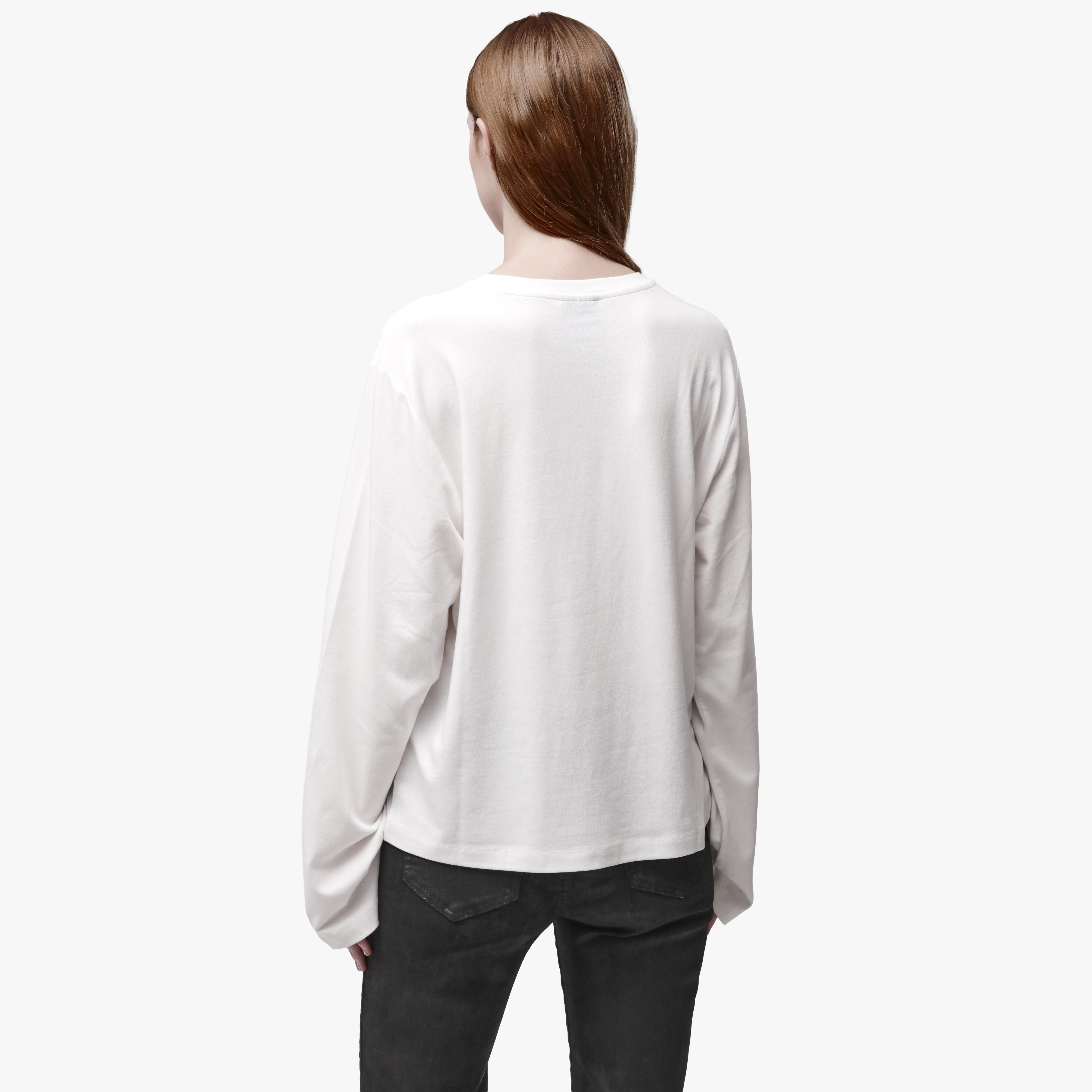Back view of a woman wearing a relaxed white long sleeve crew neck t-shirt