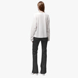 Back view of a woman wearing a relaxed white long sleeve crew neck t-shirt