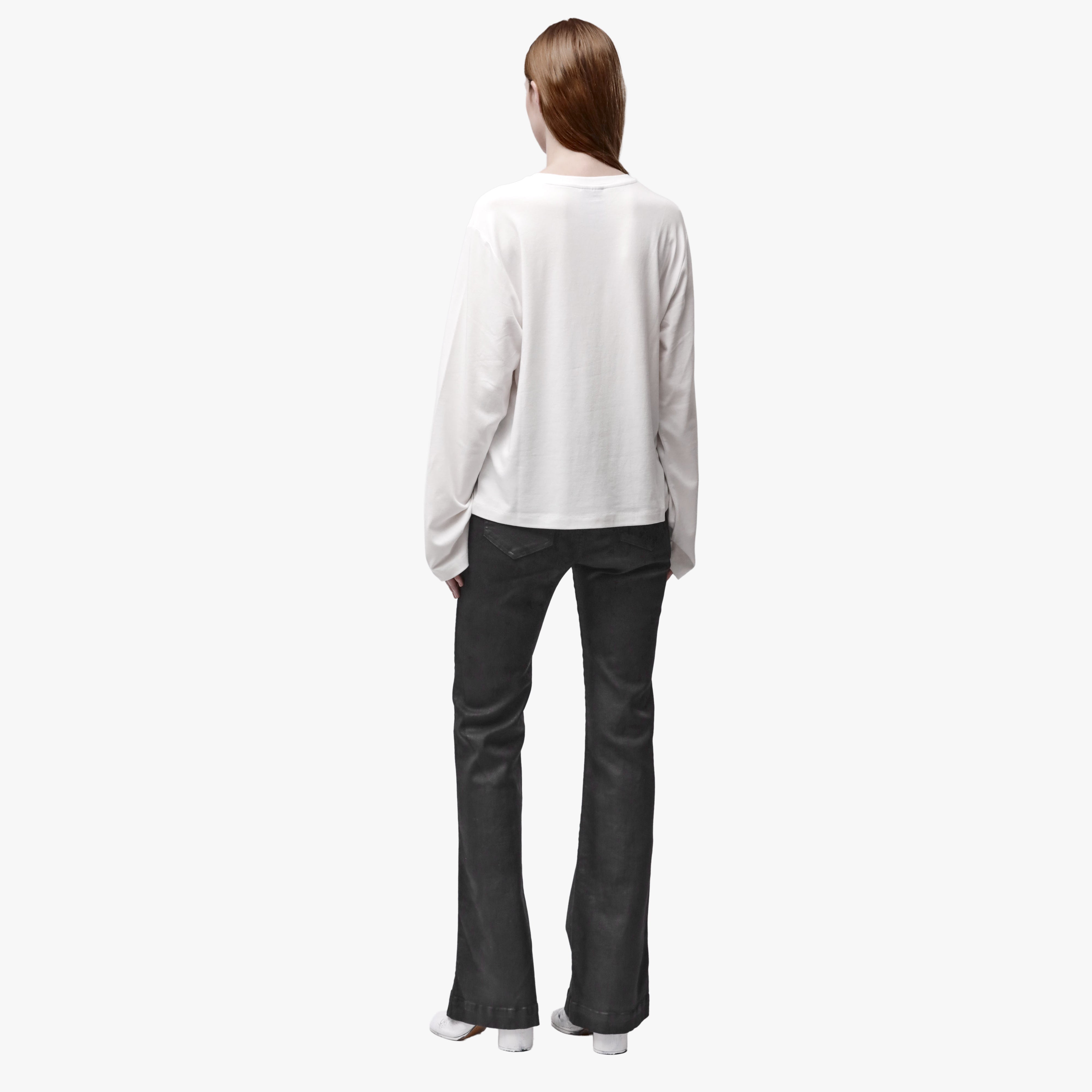 Back view of a woman wearing a relaxed white long sleeve crew neck t-shirt