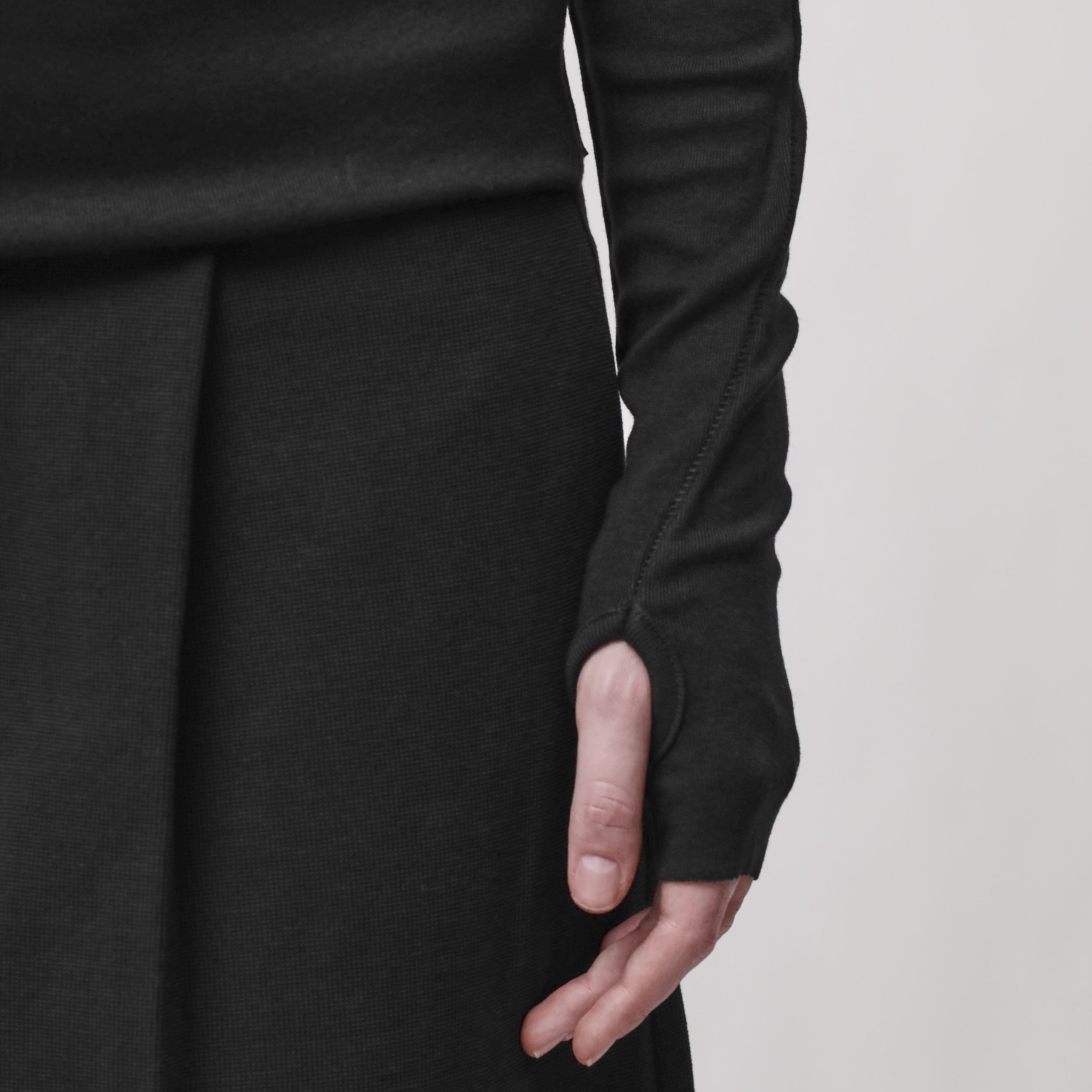 Sleeve detail of a woman wearing a long sleeve black t-shirt with a thumbhole