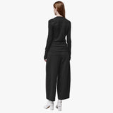 Back view of a woman wearing a black t-shirt with long sleeves, thumbholes and an asymmetric neckline