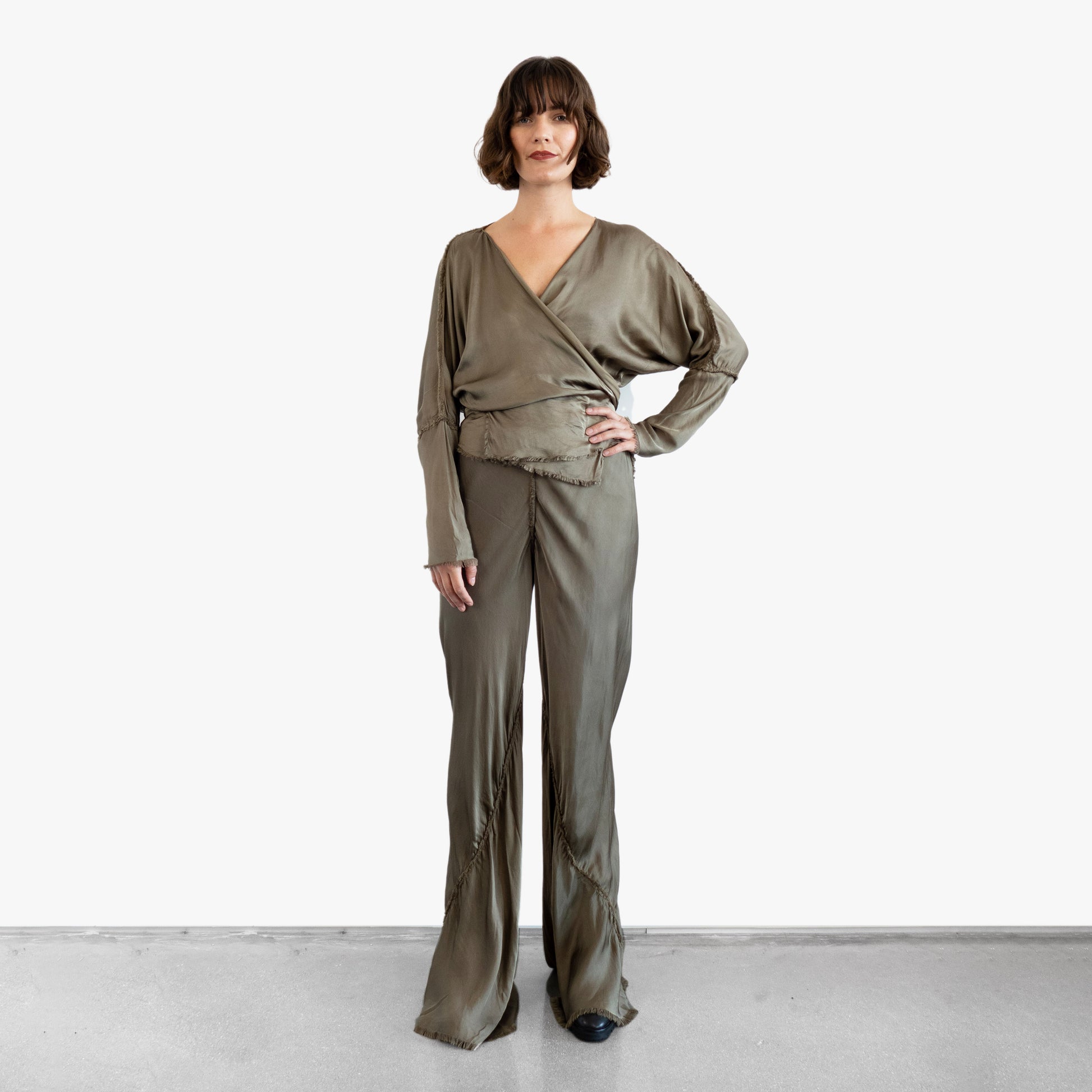 Model wearing a green silk wrap top and silk pants