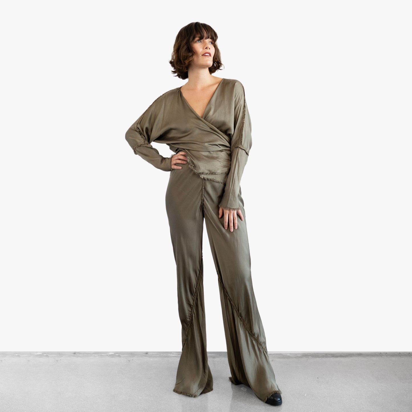 Model wearing a green silk wrap top and pants