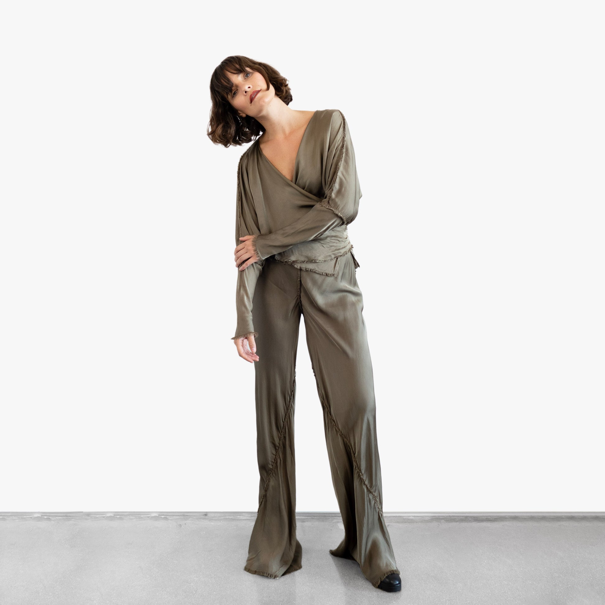 Model wearing a green silk wrap top and silk pants
